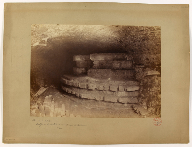 Ein altes Schwarz-Weiß-Foto eines Tunnels mit einer Treppe, die nach oben führt, mit Text unten.