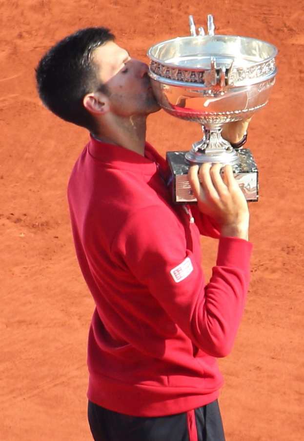 Novak Djokovic hält den French Open Pokal nach Sieg gegen Rafael Nadal im Herrensingelfinale, küsst den Pokal mit einem triumphierenden Ausdruck.