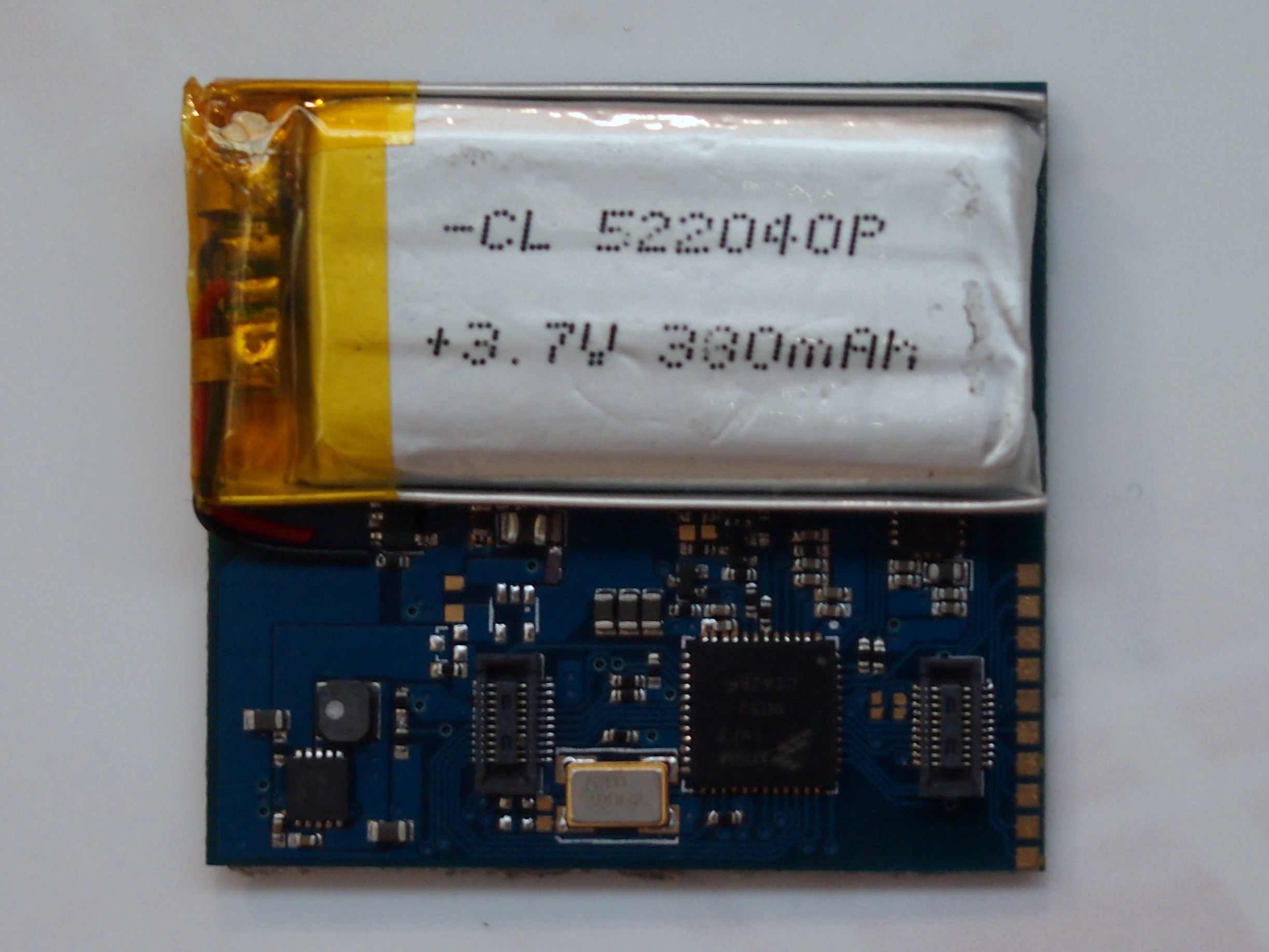 Nahaufnahme einer Mobiltelefonbatterie mit gedrucktem Text auf einer weißen Oberfläche über einer Leiterplatte.