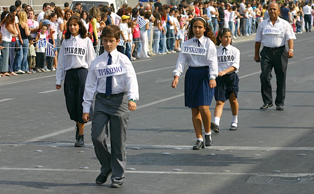 Eine Gruppe von Menschen, die auf der Straße gehen und Abzeichen auf ihren Hemden tragen, umgeben von einer großen Menge.
