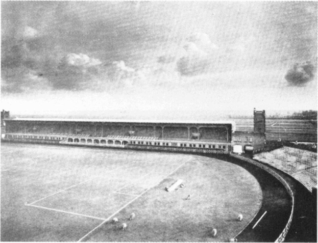 Schwarzes und weißes Foto eines Fußballfeldes mit einem Stadion, das von Bäumen umgeben ist und von einem bewölkten Himmel dominiert wird, mit dem Text "Stoke City Football Club" am unteren Rand.