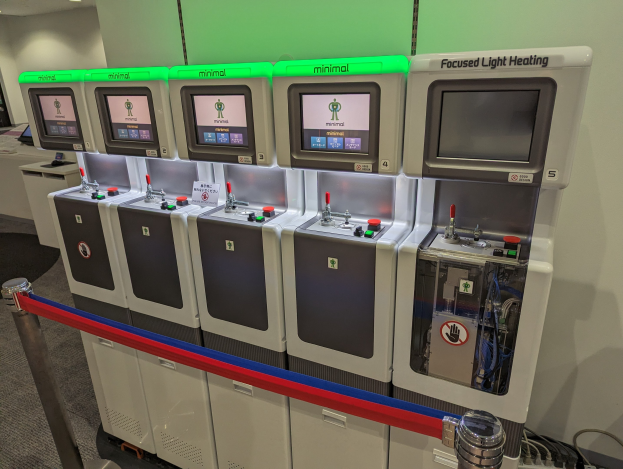 Eine Reihe von Mini-Heizungssystemgeräten mit Steuerknöpfen und -rädchen, die an einer Wand aufgereiht sind.