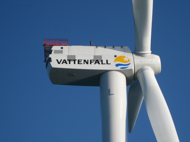 Eine weiße Windkraftanlage mit der Aufschrift "Vattenfall" vor einem hellblauen Himmel.