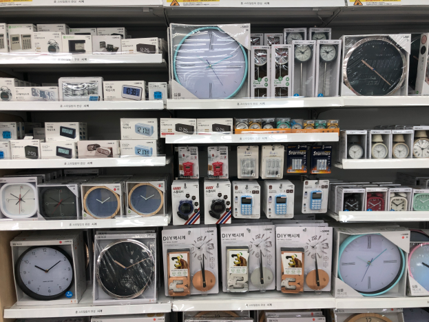 Ein gut sortierter Laden mit verschiedenen Arten von Uhren ordentlich auf Regalen angeordnet, jede mit einem Preisschild versehen.