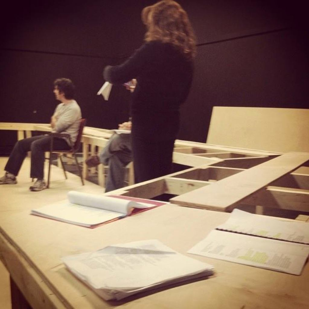 Drei Personen in der Nähe einer Bücherammlung.