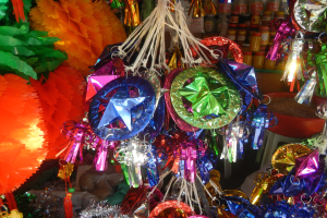 Bunte Festdekorationen, darunter Papierlaternen und Bänder, hängen von der Decke über Regalen mit Flaschen in einer feierlichen Atmosphäre.