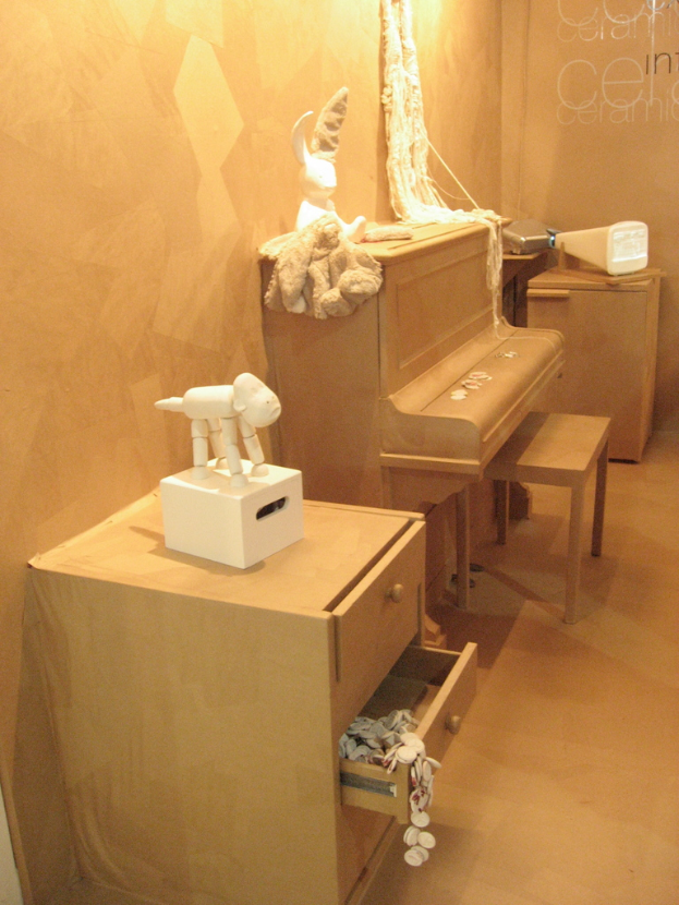 Ein Zimmer mit Schränken, einer Tastatur, einigen Spielzeugen und einer Wand.