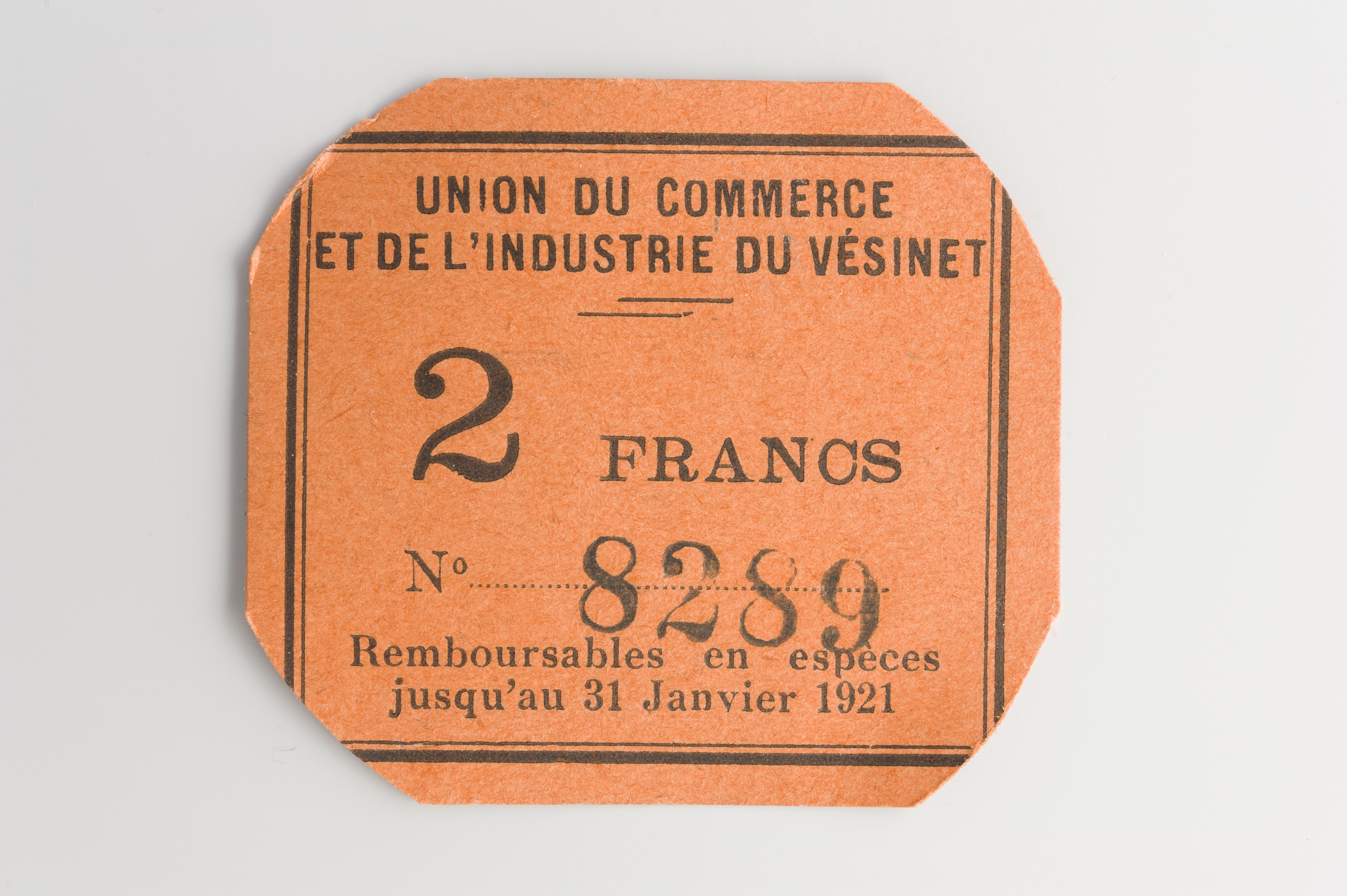Ein oranges Ticket mit den Worten "Union du Commerce et de l'Industrie du V√©sinet" darauf gegen einen weißen Hintergrund.