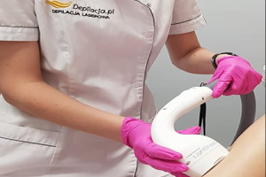 Eine Frau in einem weißen Hemd und pinken Handschuhen bedient eine weiße Laser-Haarbehandlungsmaschine an einer Wand.