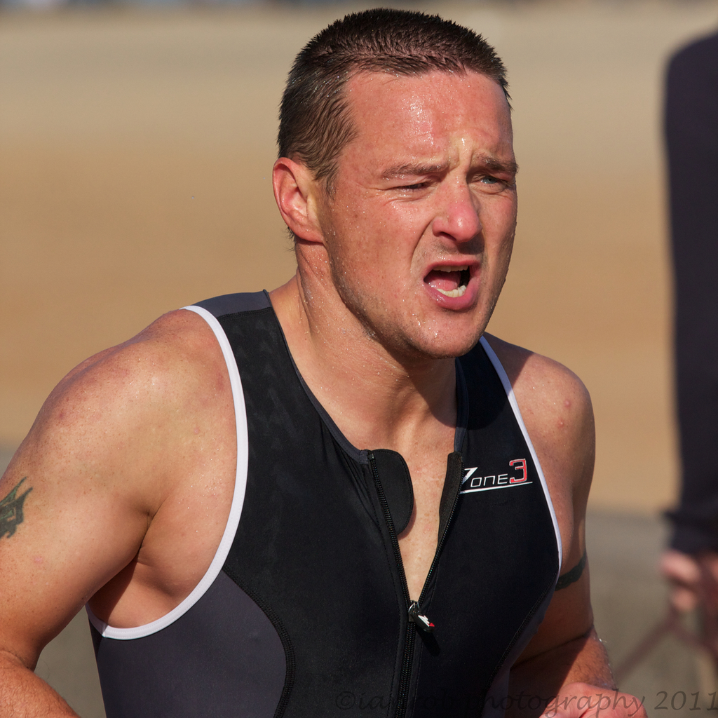 Mann in schwarzer Jacke schwitzt.