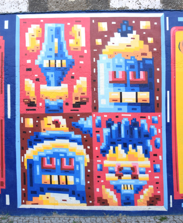 Ein leuchtendes, farbenfrohes Wandgemälde an der Seite eines Gebäudes in Berlin, Deutschland, mit verschiedenen Formen und Farben.