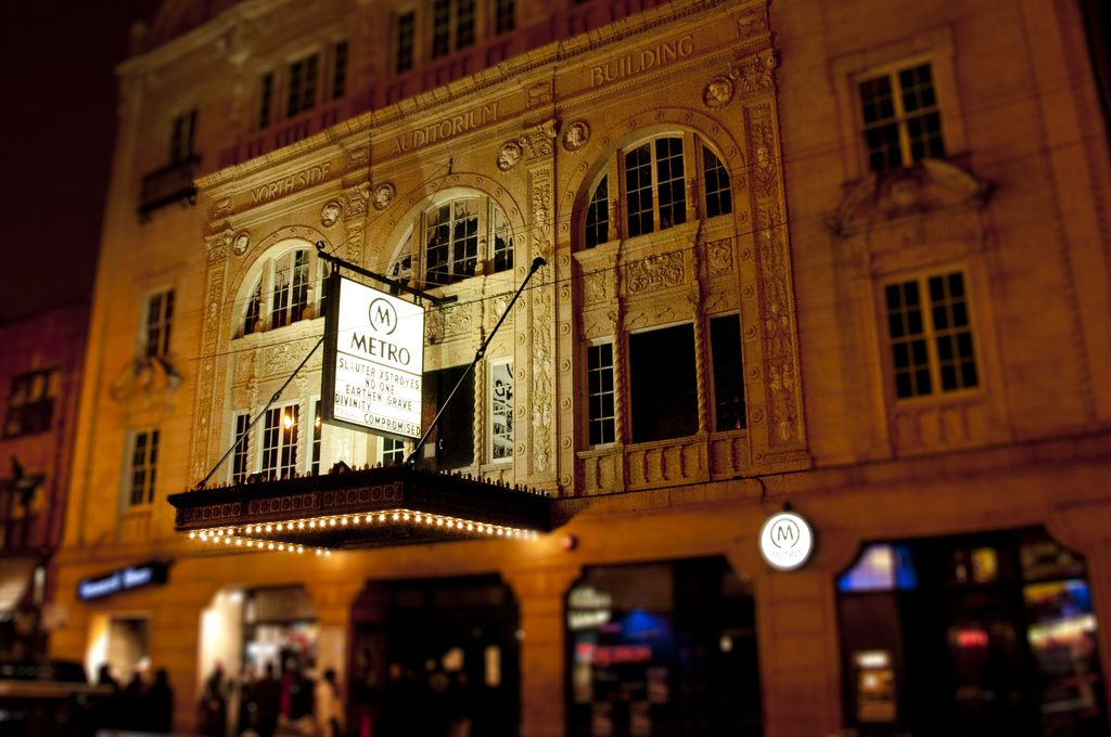 Ein gelbes Gebäude mit Geschäften und einem weißen Schild mit der Aufschrift "Metro" an der Vorderseite.