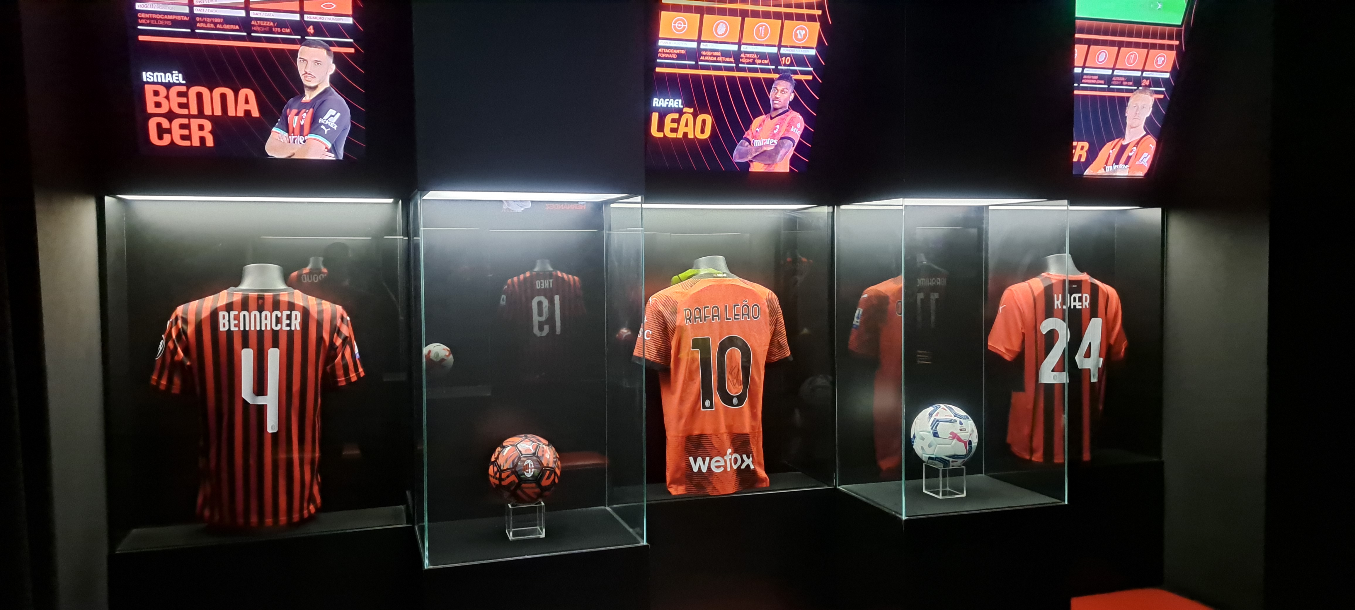 Eine Vitrine voller Fußballtrikots, die von Schaufensterpuppen getragen werden, mit einem Fußball in den Glasboxen und Bildschirmen oben, die wahrscheinlich die Spieler von Valencia CF zeigen.