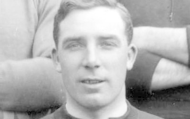 Ein Schwarz-Weiß-Foto eines Mannes in einem T-Shirt, bei dem es sich mutmaßlich um den Fußballspieler James McClean handelt, mit zwei weiteren Personen im Hintergrund.