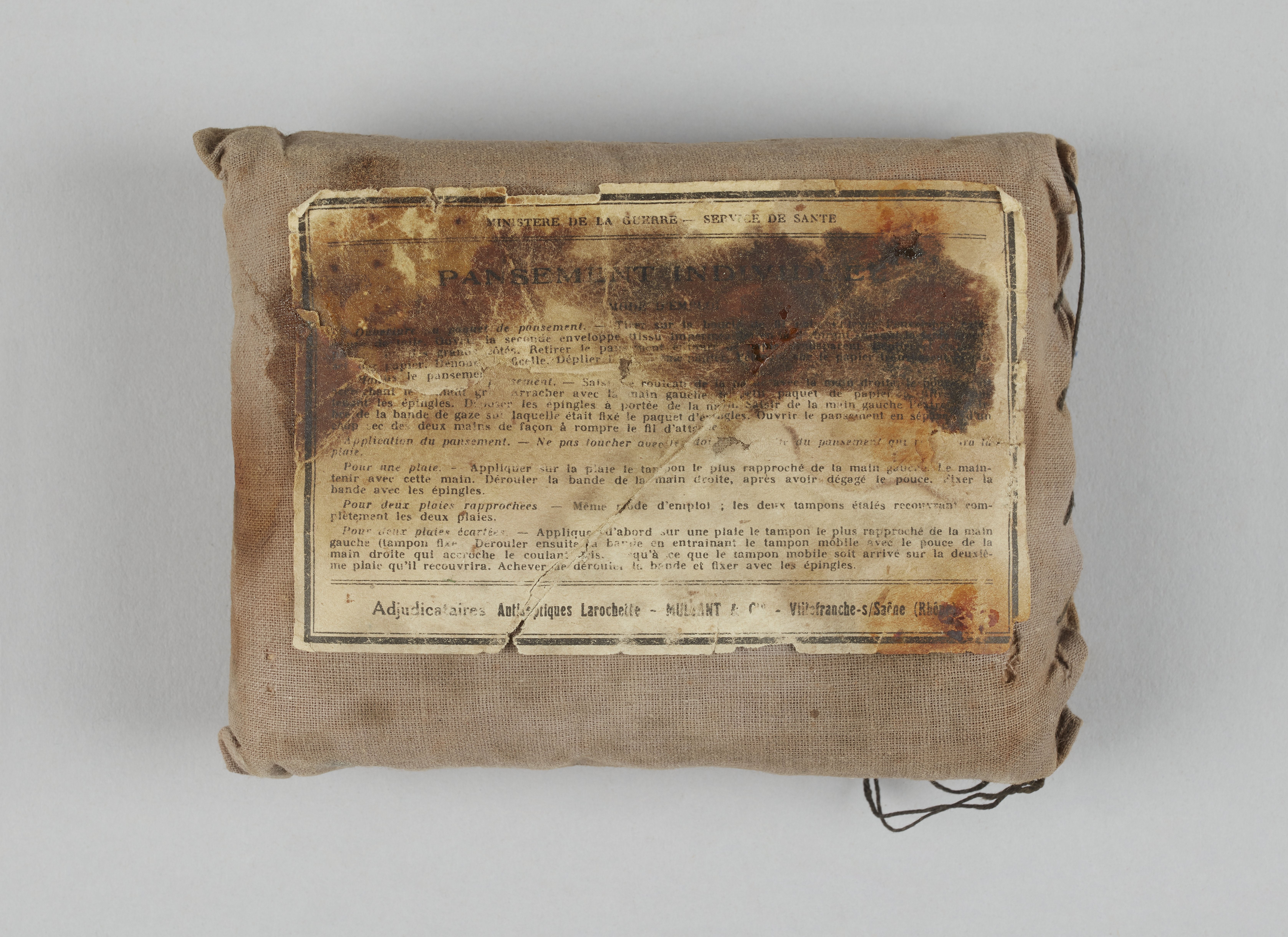 Ein kleiner Beutel mit einem Stück Papier oben drauf, wahrscheinlich ein Verbandskasten, mit Text darauf.