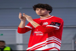 Ein Mann in rot-weißem Hemd klatscht in der Vordergrund mit einer anderen Person und einer Wand im Hintergrund, Text unten lautet "Copenhagen Futsal Club - Foto 1".