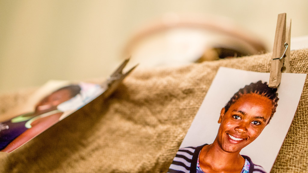 Auf einem Tisch befinden sich eine Klammer, ein Passfoto im Passformat und ein Stoffstück auf der rechten Seite, mit einem unscharfen Hintergrund und linker Seite.