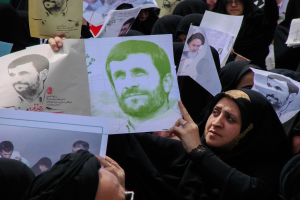 Eine Gruppe iranischer Frauen in schwarzer Kleidung, einige mit Brille, halten Bilder von Präsident Mahmoud Ahmadinejad während einer Kundgebung in Teheran.