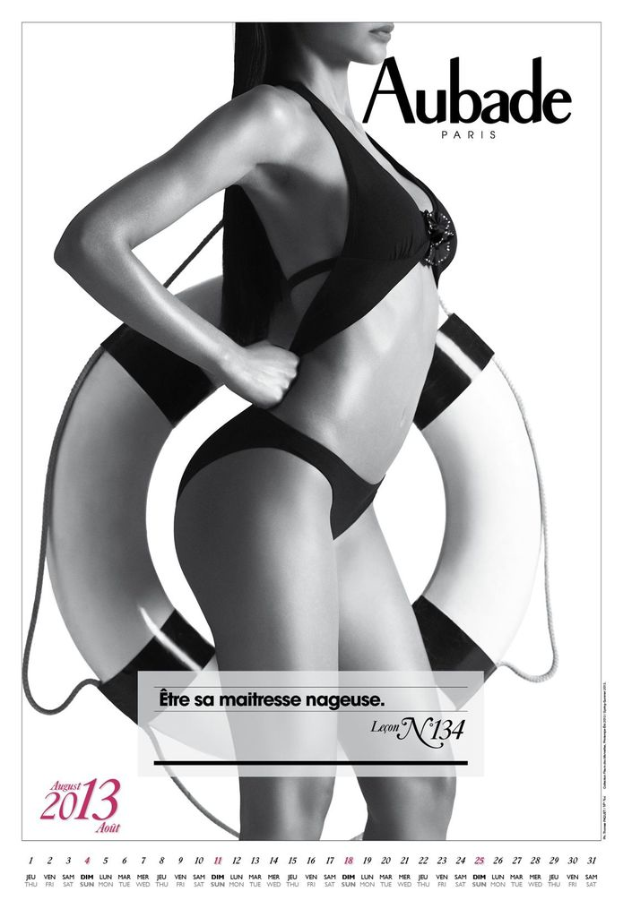 Eine Frau steht mit einem Rohr in der Hand, mit lesbarem Text und einem Datum in der unteren linken Ecke vor einem weißen Hintergrund.